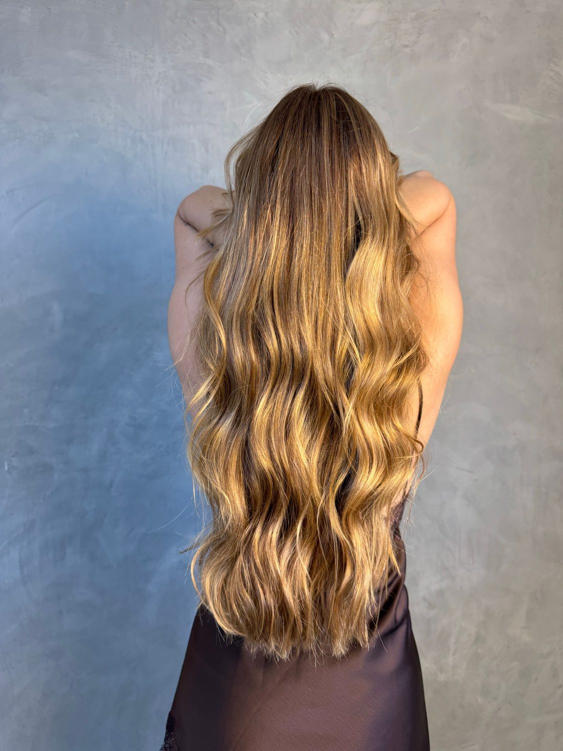 Balayage en tonos miel en melena larga con ondas